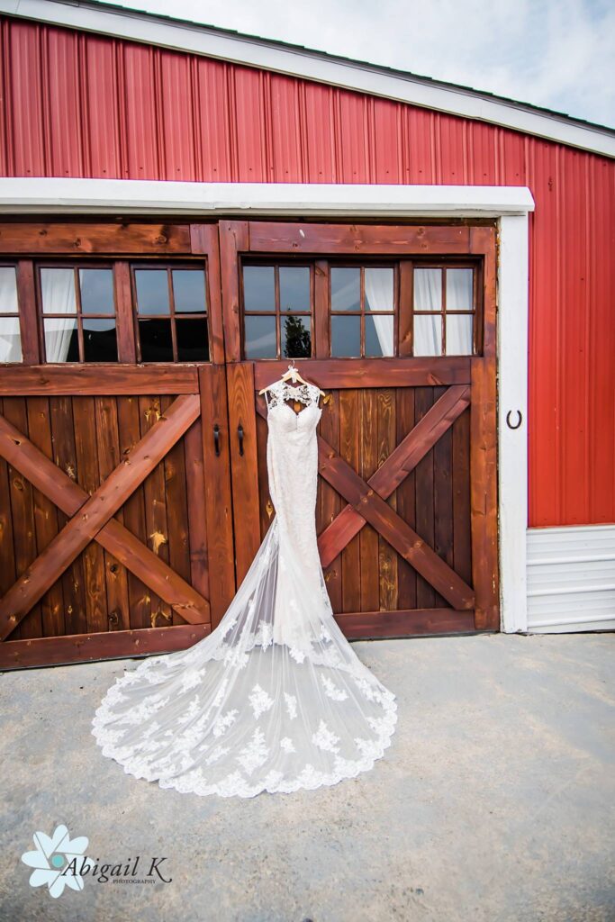 wedding gown hanging on venue barn doors